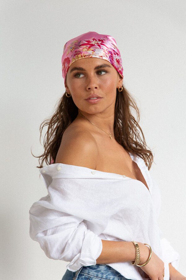 Foto van sjaal KIRSTEN, een met fris rose kleur geaccentueerde sjaal met elegant bloemen-ontwerp gedragen als hoofdband.